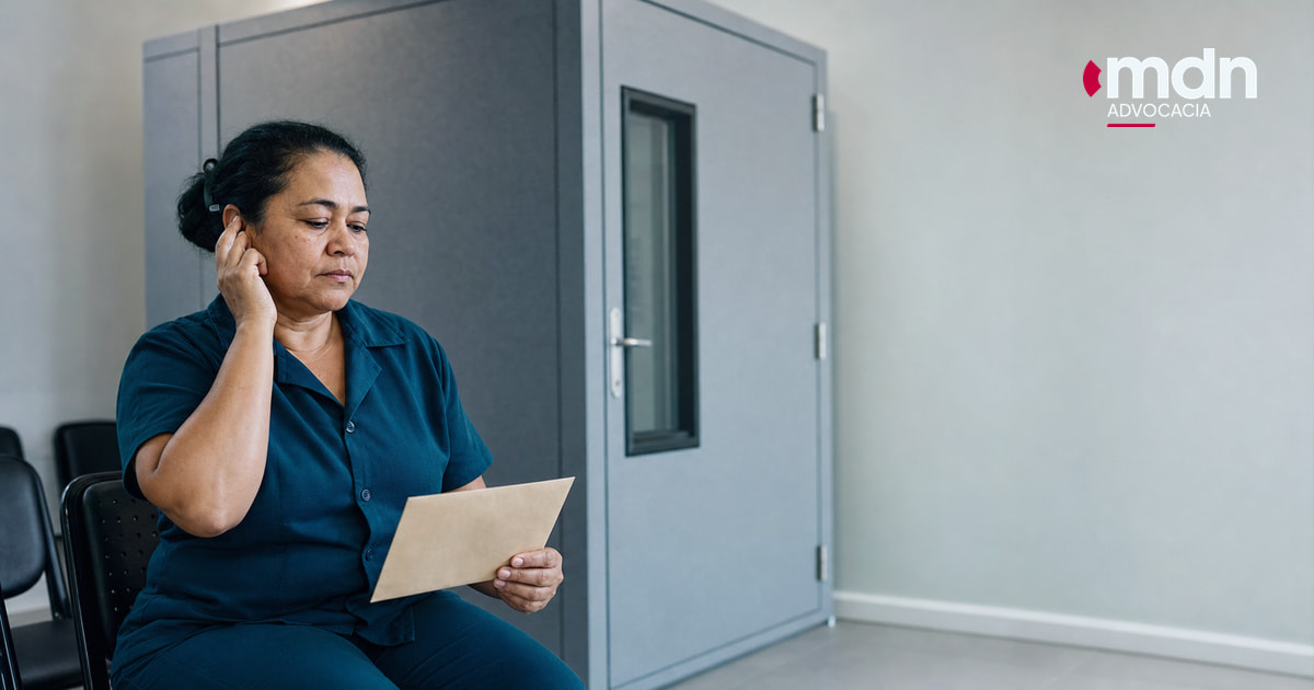 Trabalhadora recebe resultado de audiometria ocupacional após exame em cabine acústica Trabalhadora recebe resultado de audiometria ocupacional após exame em cabine acústica