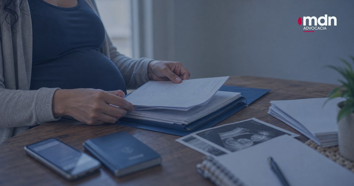 Imagem destacada - Documentos para processo por demissão de grávida: checklist Documentos para processo por demissão de grávida organizados com ultrassom e carteira de trabalho sobre uma mesa.